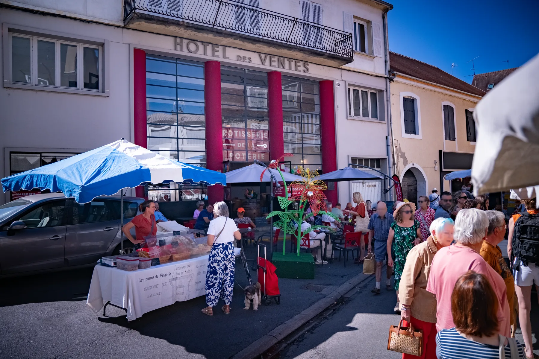 La façade de la rôtisserie un jour de marché, terrasse pleine sous les parasols