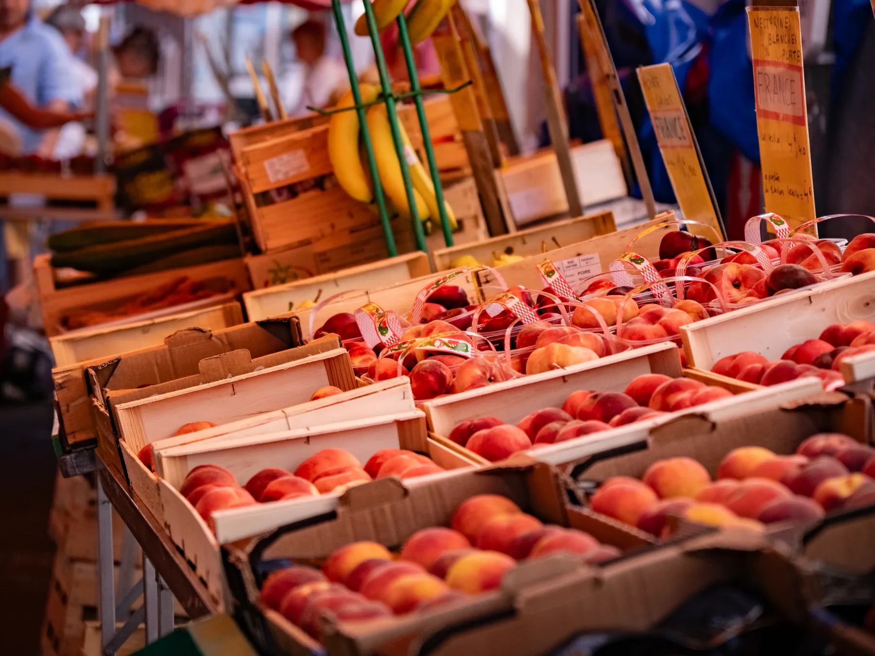 Cagettes de pêches et nectarines de France sur l'étal du marché