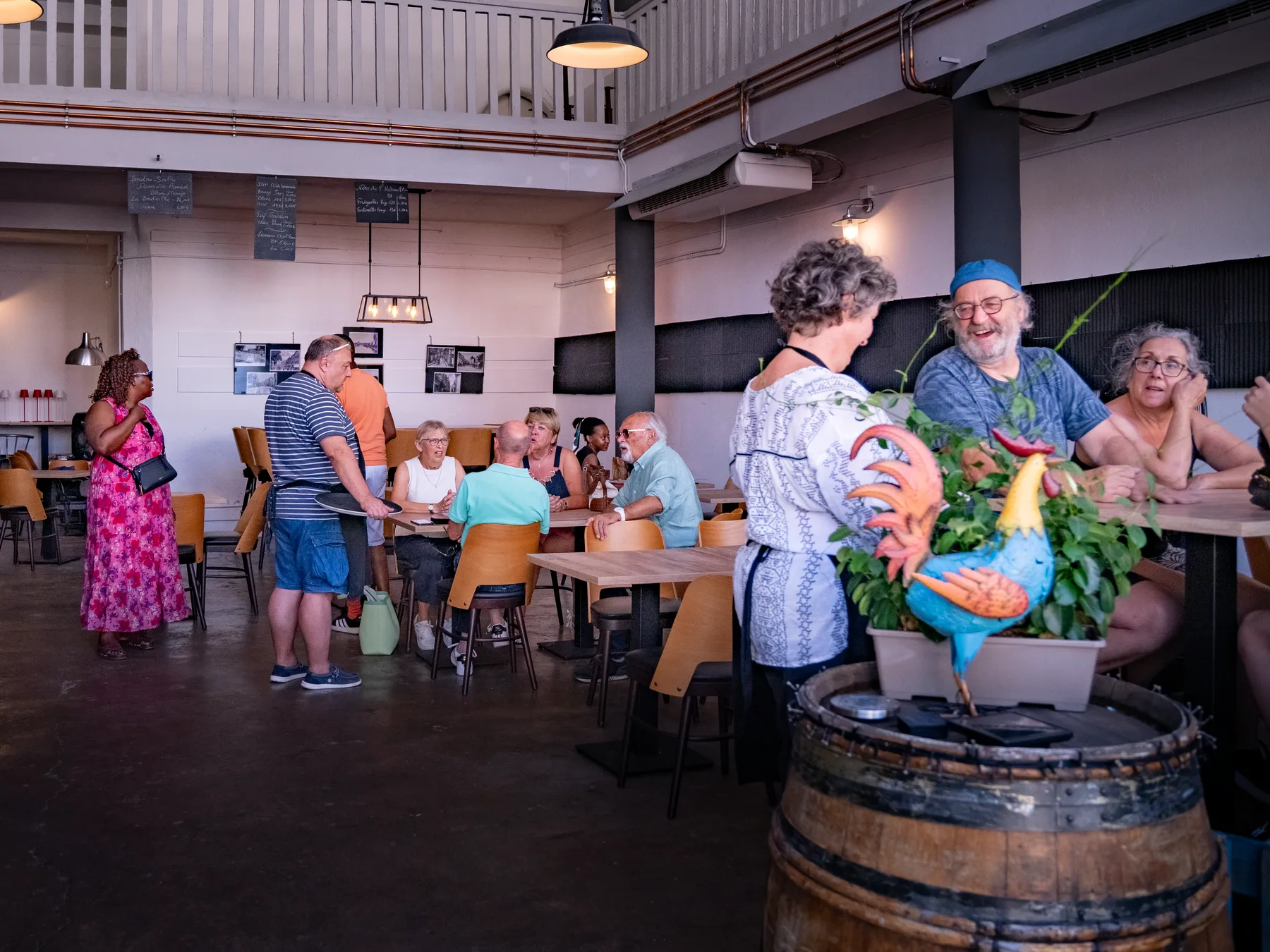 La salle de la rôtisserie remplie de clients attablés, un serveur en salle